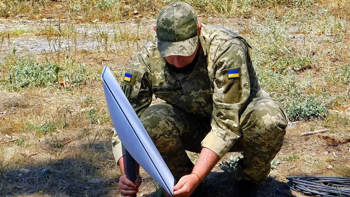 A Ukrainian soldier setting up a Starlink terminal